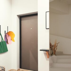 Black stainless steel baseball cap organizer rack mounted on wall holding multiple baseball caps for closet and bedroom storage.