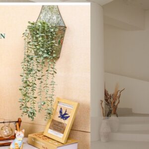 Artificial hanging eucalyptus plant in a decorative pot displayed on a shelf in a modern boho farmhouse living room.